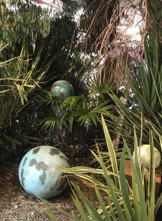 Bronze sphere sculpture in situ among tropical plants