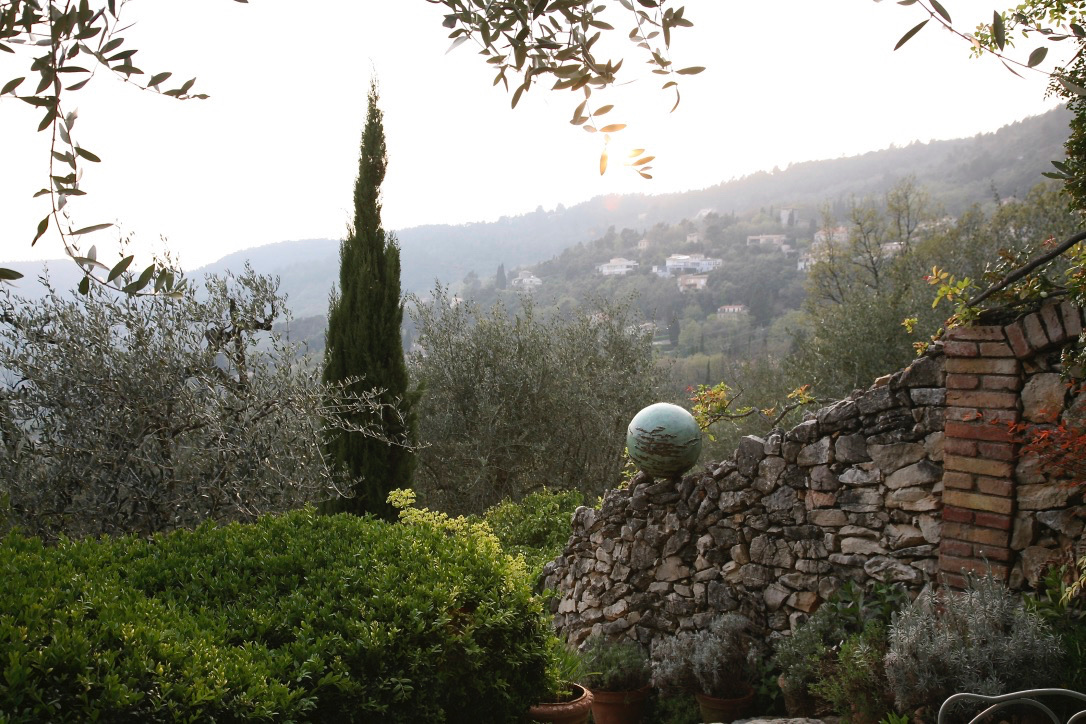 Bronze sphere sculpture in situ with hillside landscape view